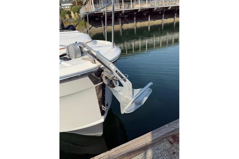 Evangaline Yacht Photos Pics 2022 Ranger Tugs R-25 boat with anchor, docked near waterfront building.