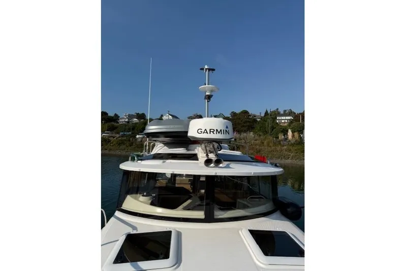 Evangaline Yacht Photos Pics 2022 Ranger Tugs R-25 boat with Garmin equipment, docked near a scenic shoreline.