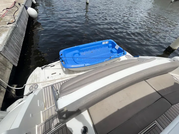 Summer Girl Yacht Photos Pics 2007 Cruisers Yachts 497 Sport Sedan docked with a blue dinghy on the platform.