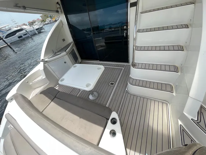 Summer Girl Yacht Photos Pics 2007 Cruisers Yachts 497 Sport Sedan, spacious deck with seating and table, docked at marina.