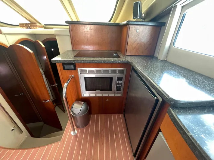 Summer Girl Yacht Photos Pics 2007 Cruisers Yachts 497 Sport Sedan kitchen with microwave, fridge, and wood cabinetry.