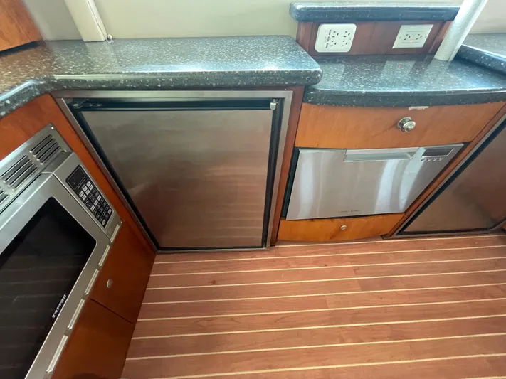 Summer Girl Yacht Photos Pics 2007 Cruisers Yachts 497 Sport Sedan kitchen with stainless appliances and wood flooring.