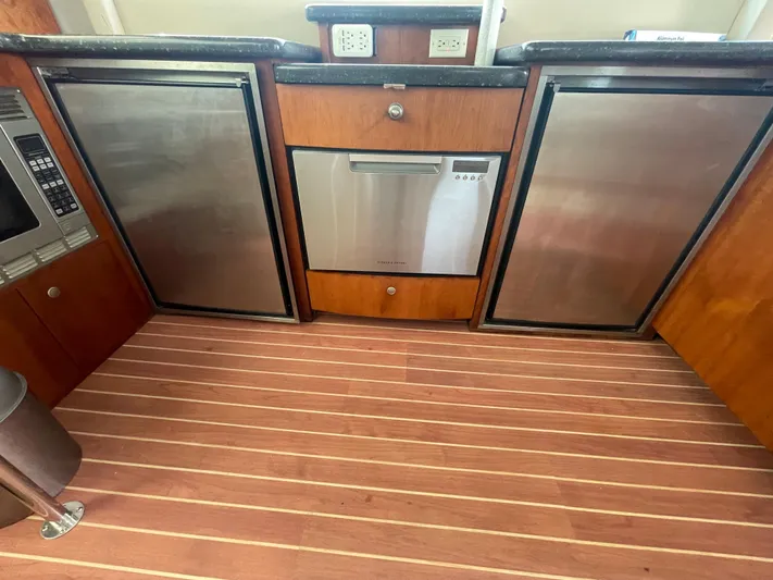 Summer Girl Yacht Photos Pics 2007 Cruisers Yachts 497 Sport Sedan kitchen with stainless appliances and wood flooring.