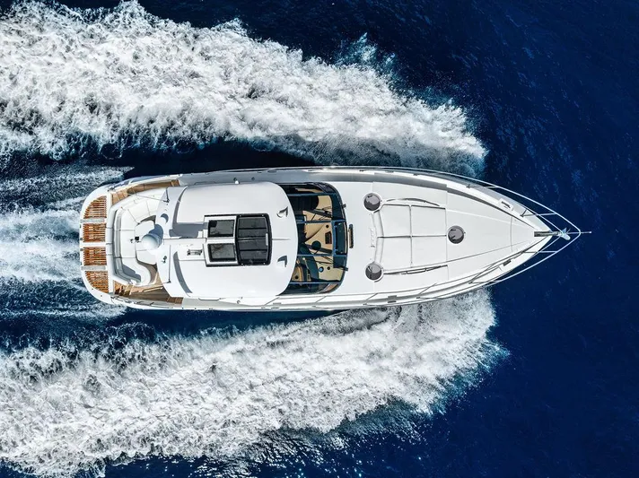  Yacht Photos Pics Aerial view of 2003 Neptunus 56 Express yacht cruising on blue ocean waters.