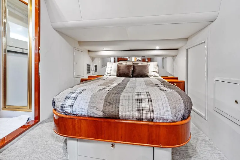  Yacht Photos Pics Luxurious cabin interior of 2003 Neptunus 56 Express yacht with cozy bed and elegant wood finish.