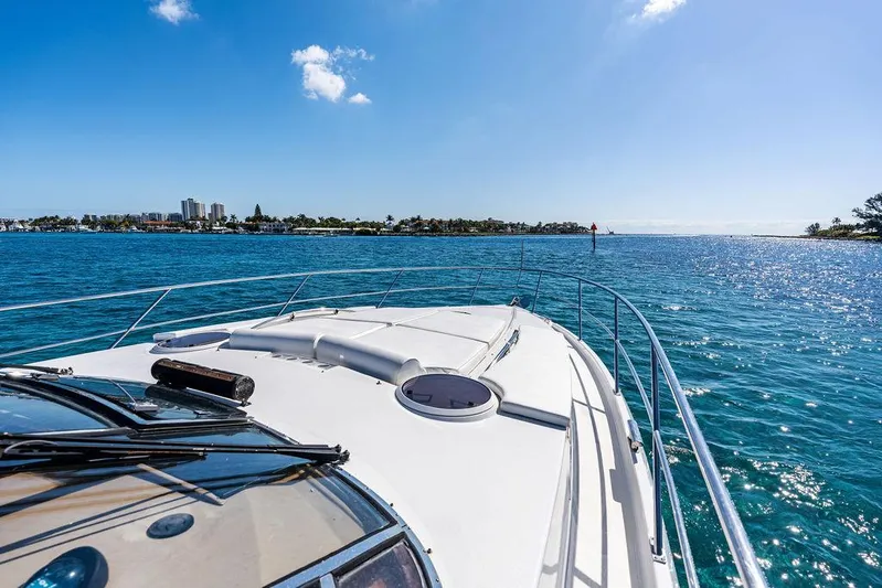  Yacht Photos Pics 2003 Neptunus 56 Express yacht cruising on a sunny, clear blue sea.