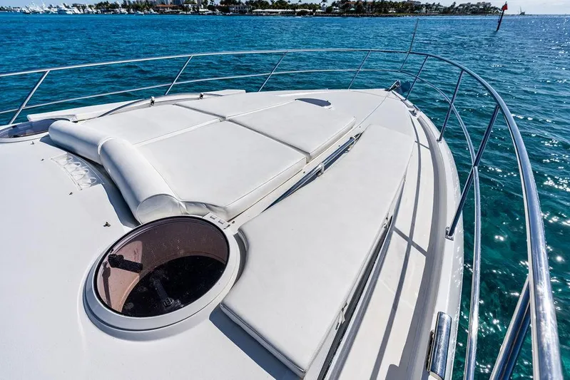  Yacht Photos Pics 2003 Neptunus 56 Express yacht deck with sunbathing area, overlooking blue ocean waters.