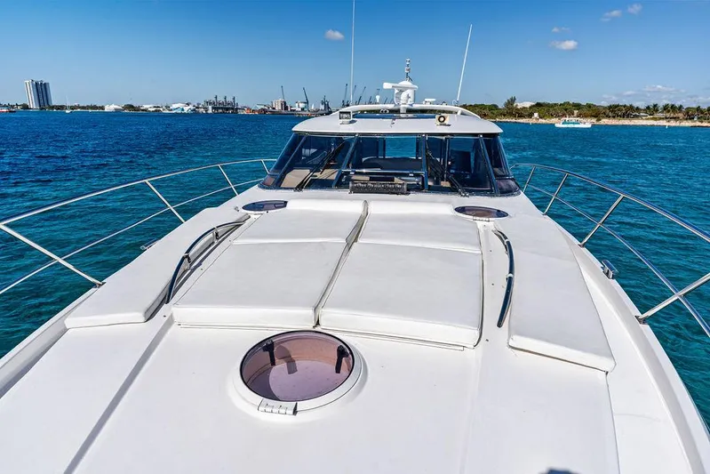  Yacht Photos Pics 2003 Neptunus 56 Express yacht on blue ocean, clear sky, and distant shoreline.