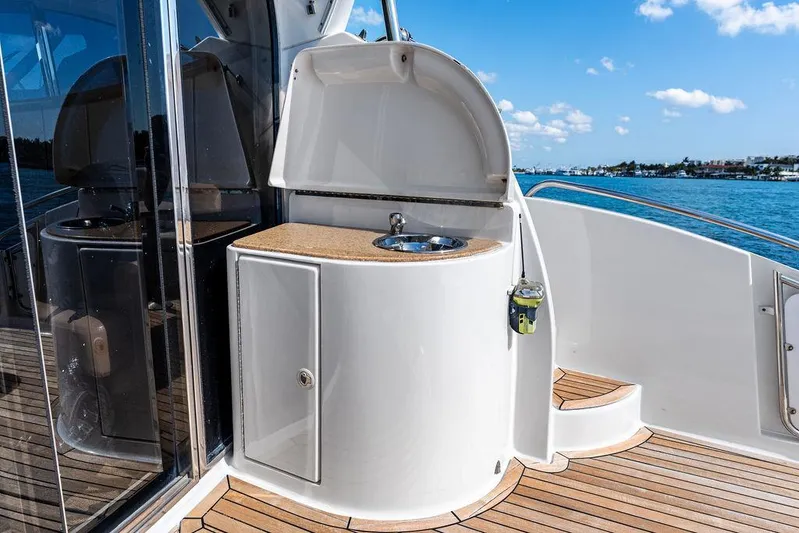  Yacht Photos Pics 2003 Neptunus 56 Express yacht deck with sink and storage, overlooking serene waters.