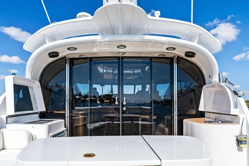  Yacht Photos Pics 2003 Neptunus 56 Express yacht with sleek design and glass doors under a clear blue sky.