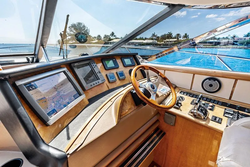  Yacht Photos Pics Helm of 2003 Neptunus 56 Express yacht with navigation screens and wooden steering wheel.