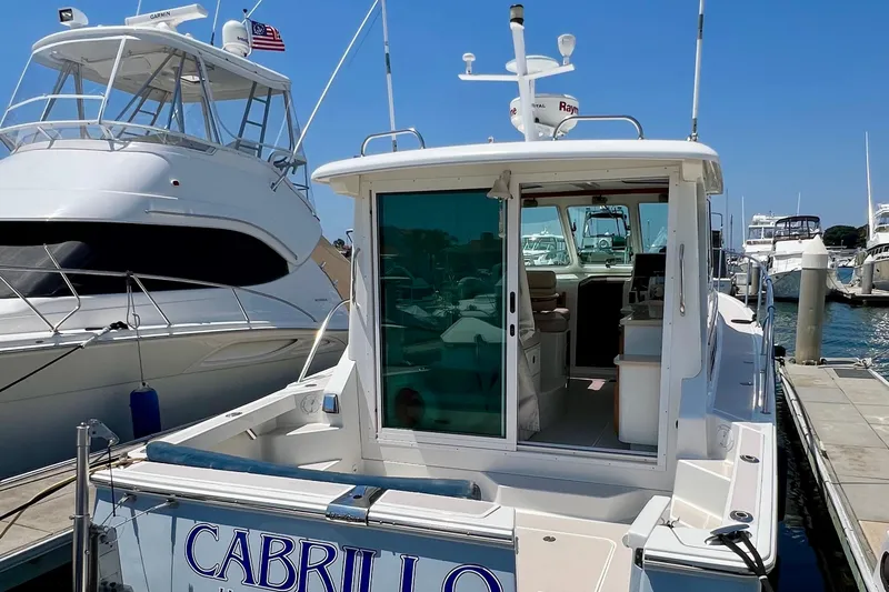 Cabrillo Yacht Photos Pics 2008 Back Cove 33 Express docked at marina, rear view with open cabin.