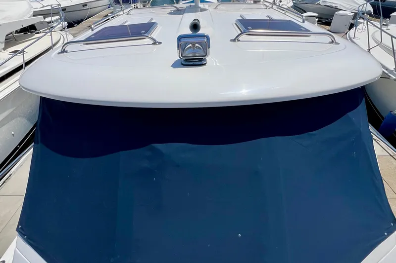 Cabrillo Yacht Photos Pics 2008 Back Cove 33 Express yacht with blue canvas cover, docked among other boats.