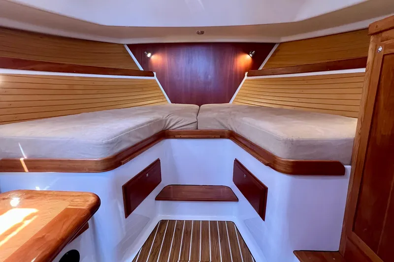 Cabrillo Yacht Photos Pics 2008 Back Cove 33 Express cabin interior with wooden accents and cozy bedding.