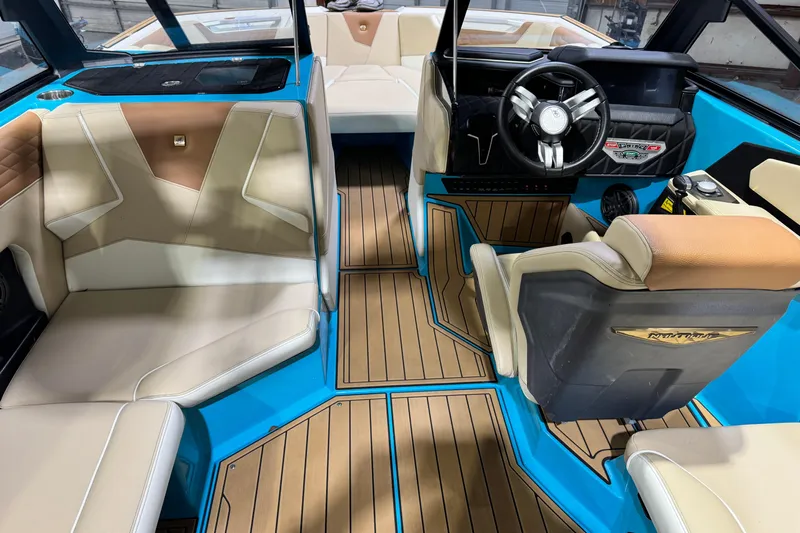  Yacht Photos Pics 2023 Nautique Super Air Nautique S23 interior with blue accents and luxurious seating.