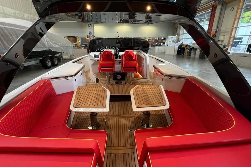 Manda 07 Yacht Photos Pics 2024 Frauscher 1414 Demon Air luxury boat interior with red seating and wooden tables.