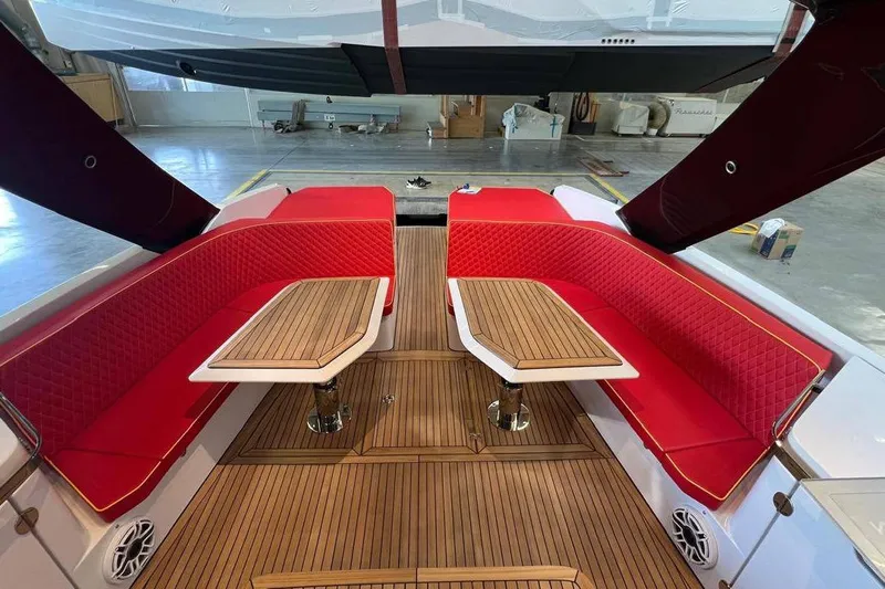 Manda 07 Yacht Photos Pics Luxurious 2024 Frauscher 1414 Demon Air yacht interior with red seating and wooden tables.