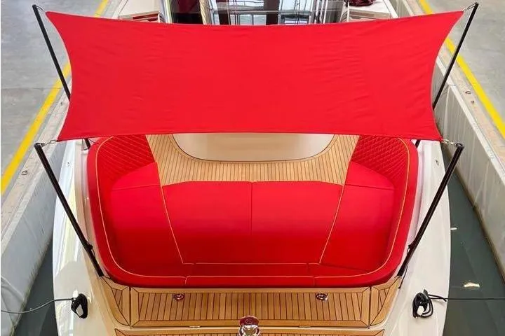 Manda 07 Yacht Photos Pics 2024 Frauscher 1414 Demon Air boat with red canopy and seating, docked indoors.