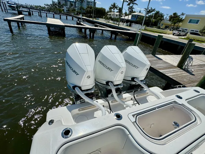  Yacht Photos Pics 2020 Invincible 36' Open Fisherman with triple Mercury outboard engines docked by the water.