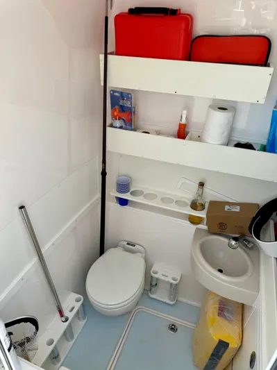  Yacht Photos Pics 2020 Invincible 36' Open Fisherman boat bathroom with toilet, sink, and storage shelves.