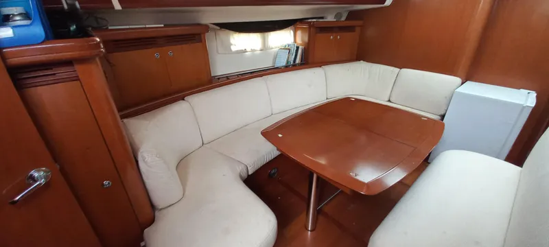 Kaskara Yacht Photos Pics Interior of 2007 Beneteau Oceanis Clipper 523 with cozy seating and wooden table.