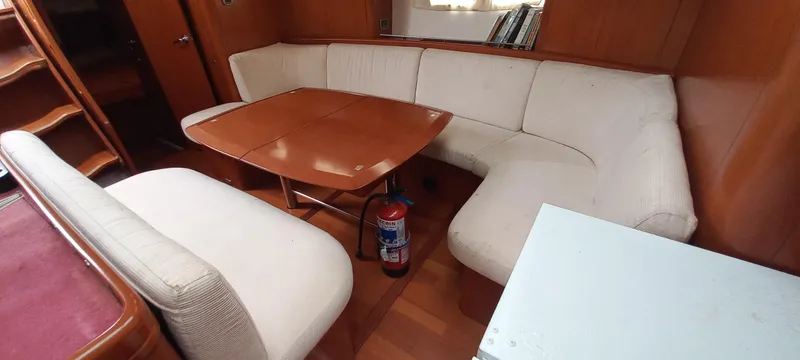 Kaskara Yacht Photos Pics Interior of 2007 Beneteau Oceanis Clipper 523 with white seating and wooden table.