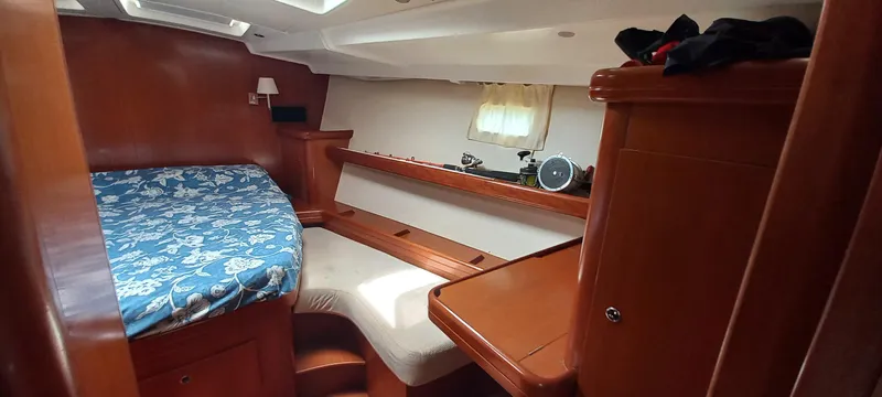Kaskara Yacht Photos Pics Cozy cabin interior of 2007 Beneteau Oceanis Clipper 523 with wooden furnishings and bed.