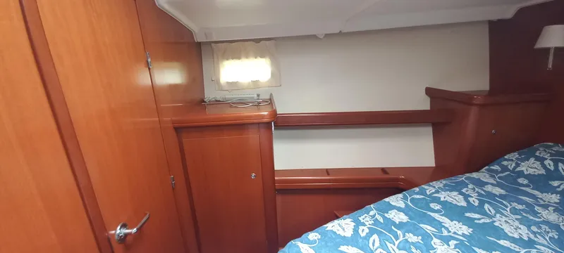 Kaskara Yacht Photos Pics Interior cabin of 2007 Beneteau Oceanis Clipper 523 with wooden finish and floral bedding.