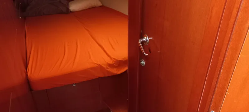 Kaskara Yacht Photos Pics Cozy cabin interior of 2007 Beneteau Oceanis Clipper 523 with orange bedding.