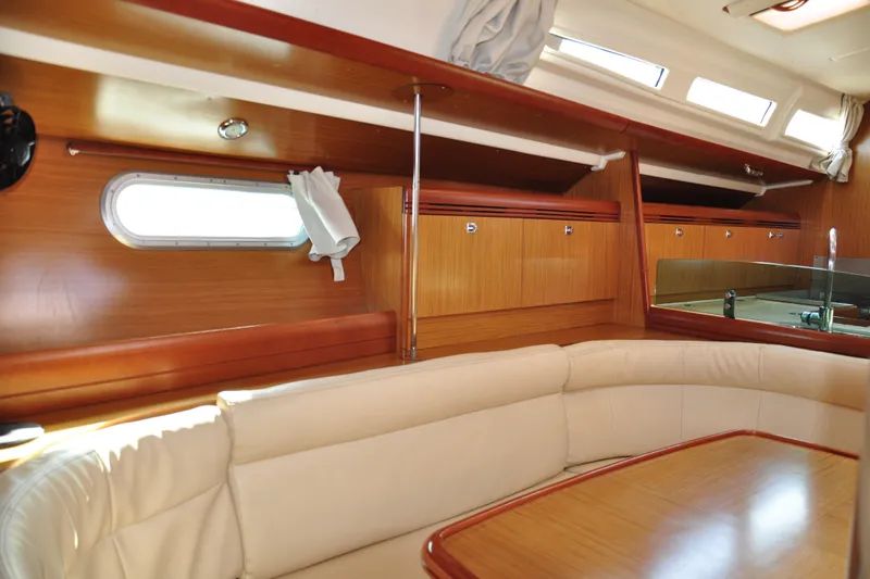 Billmaira Yacht Photos Pics Interior of 2008 Jeanneau Sun Odyssey 42i yacht with wooden cabinetry and cream seating.