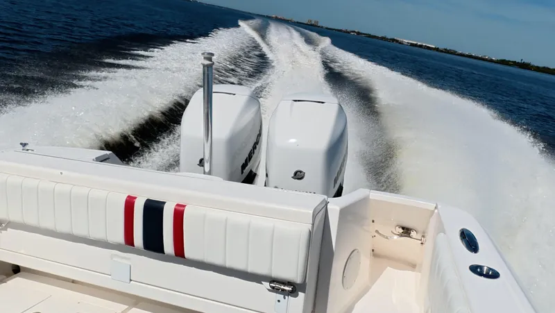 Johnny Be Good Yacht Photos Pics 2012 Intrepid 327 CC boat cruising on open water, leaving a wake behind.