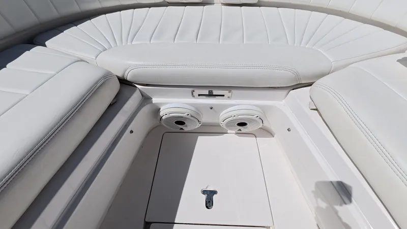 Johnny Be Good Yacht Photos Pics 2012 Intrepid 327 CC boat interior with white cushioned seating and built-in speakers.