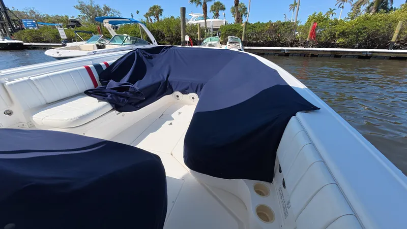 Johnny Be Good Yacht Photos Pics 2012 Intrepid 327 CC boat with blue covers docked by the water.