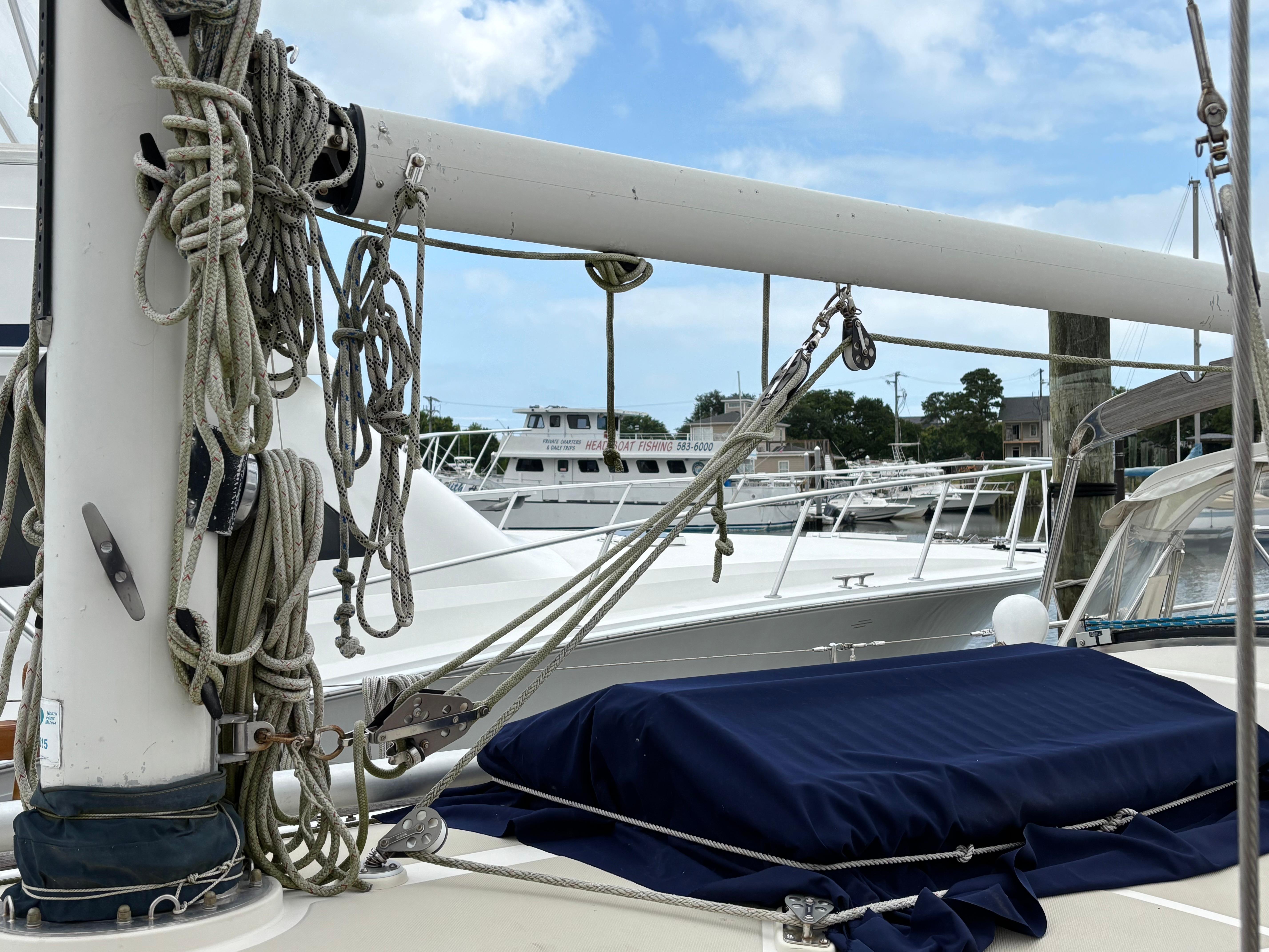 Sailboat rigging on 1987 Ta Shing Tashiba 36, docked at marina under blue sky.