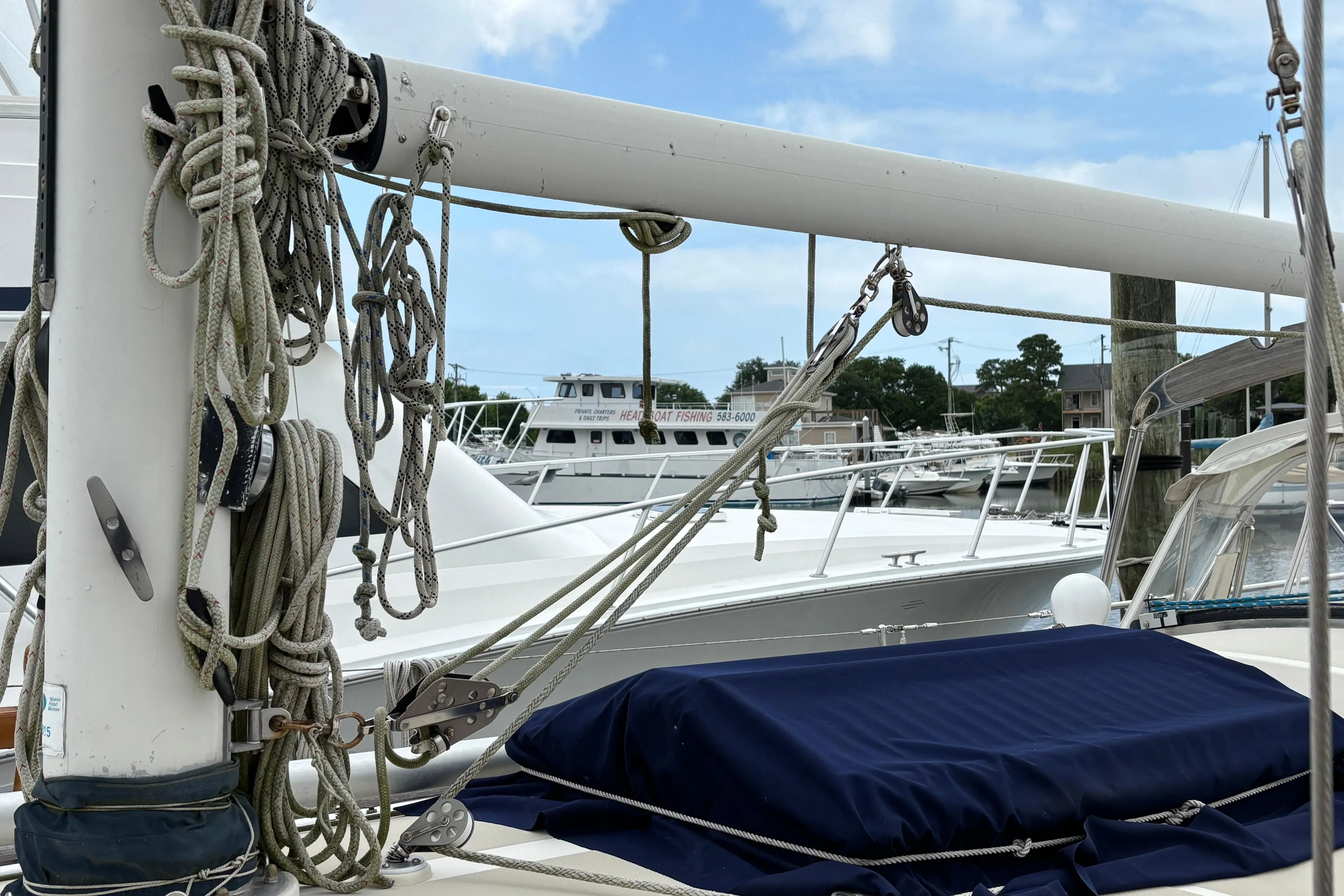 Sailboat rigging on 1987 Ta Shing Tashiba 36, docked at marina under blue sky.