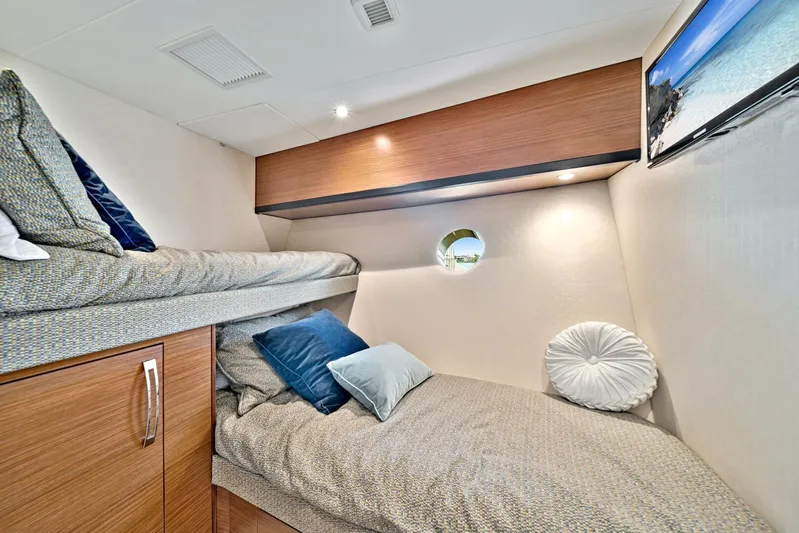 West Yacht Photos Pics Cozy cabin interior of 2017 Hatteras 60 Motor Yacht with twin beds and modern decor.