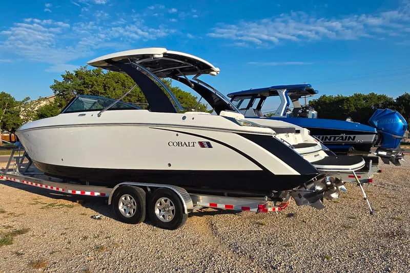  Yacht Photos Pics 2023 Cobalt R30 boat on trailer, parked outdoors under a clear blue sky.