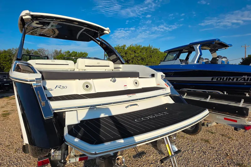  Yacht Photos Pics 2023 Cobalt R30 boat with sleek design, parked outdoors under a clear blue sky.