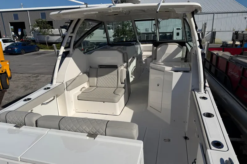  Yacht Photos Pics 2023 Pursuit DC 295 Dual Console boat interior with seating and storage, docked outdoors.