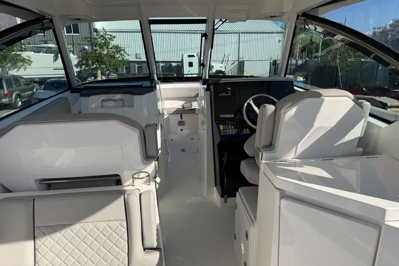  Yacht Photos Pics 2023 Pursuit DC 295 Dual Console interior with modern seating and steering wheel.