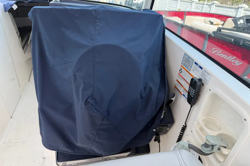  Yacht Photos Pics 2023 Pursuit DC 295 Dual Console boat interior with covered equipment and communication device.