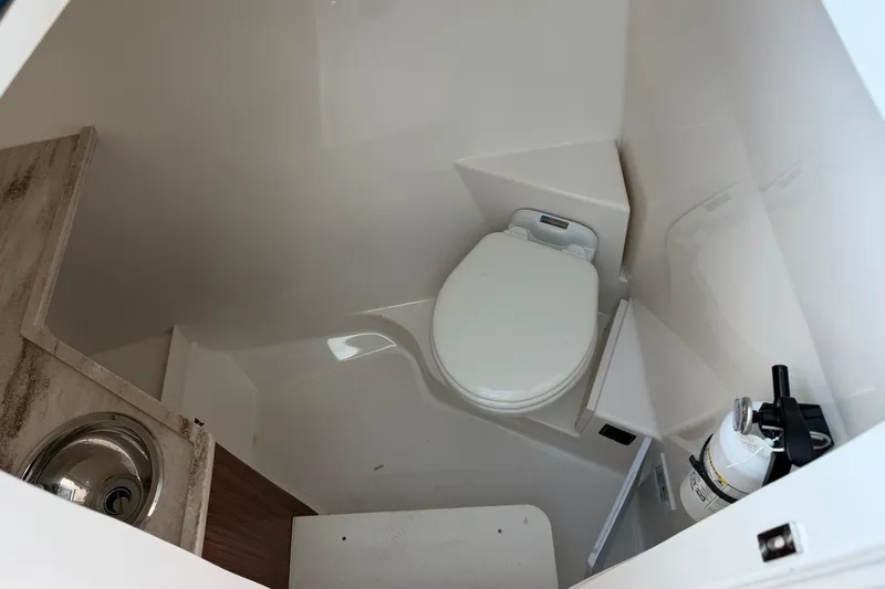  Yacht Photos Pics 2023 Pursuit DC 295 Dual Console boat interior bathroom with toilet and sink.