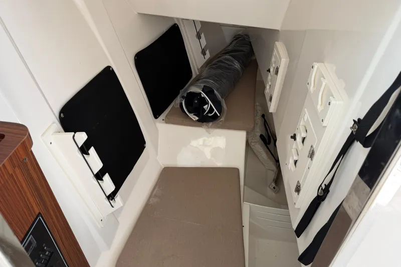  Yacht Photos Pics 2023 Pursuit DC 295 Dual Console cabin interior with seating and storage compartments.