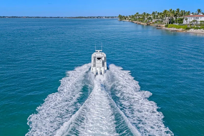 New Stock Yacht Photos Pics 2026 Yellowfin 36 Offshore boat cruising on clear blue water near a tropical coastline.