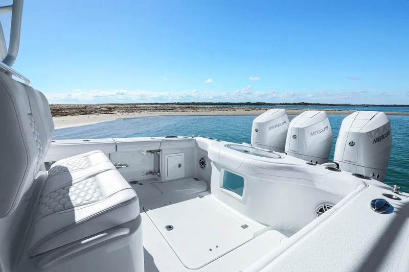 New Stock Yacht Photos Pics 2026 Yellowfin 36 Offshore boat with Mercury engines near a sandy shore.