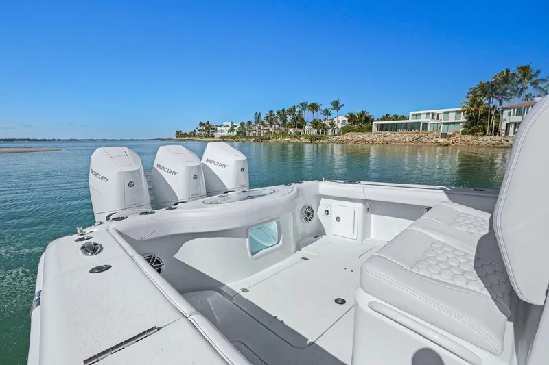 New Stock Yacht Photos Pics 2026 Yellowfin 36 Offshore boat with triple Mercury engines, near luxury waterfront homes.