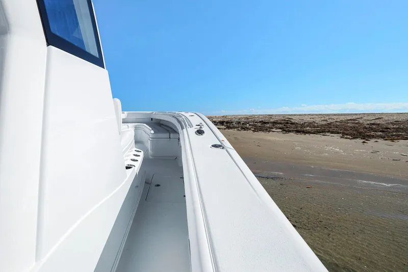 New Stock Yacht Photos Pics 2026 Yellowfin 36 Offshore boat on sandy beach under clear blue sky.