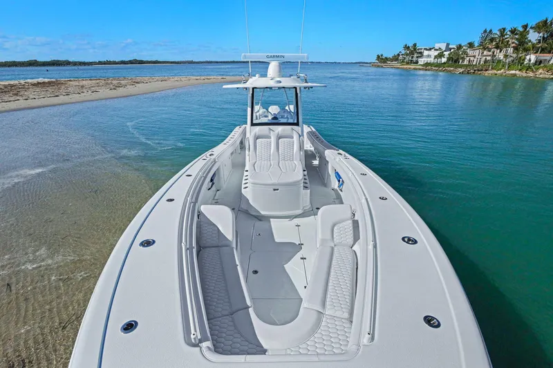 New Stock Yacht Photos Pics 2026 Yellowfin 36 Offshore boat on clear blue water near a sandy shore.