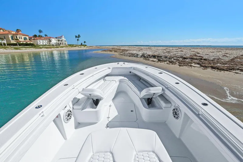 New Stock Yacht Photos Pics 2026 Yellowfin 36 Offshore boat docked on a sandy beach with clear blue water.