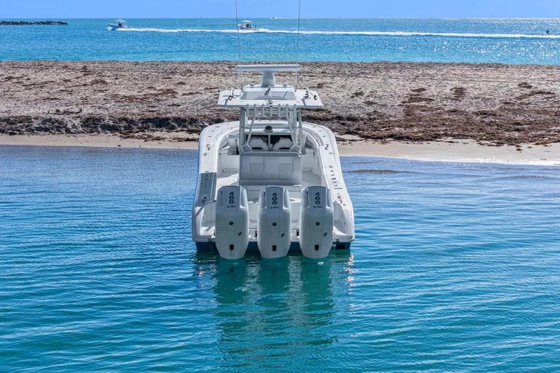 New Stock Yacht Photos Pics 2026 Yellowfin 36 Offshore boat with quad engines near sandy beach.